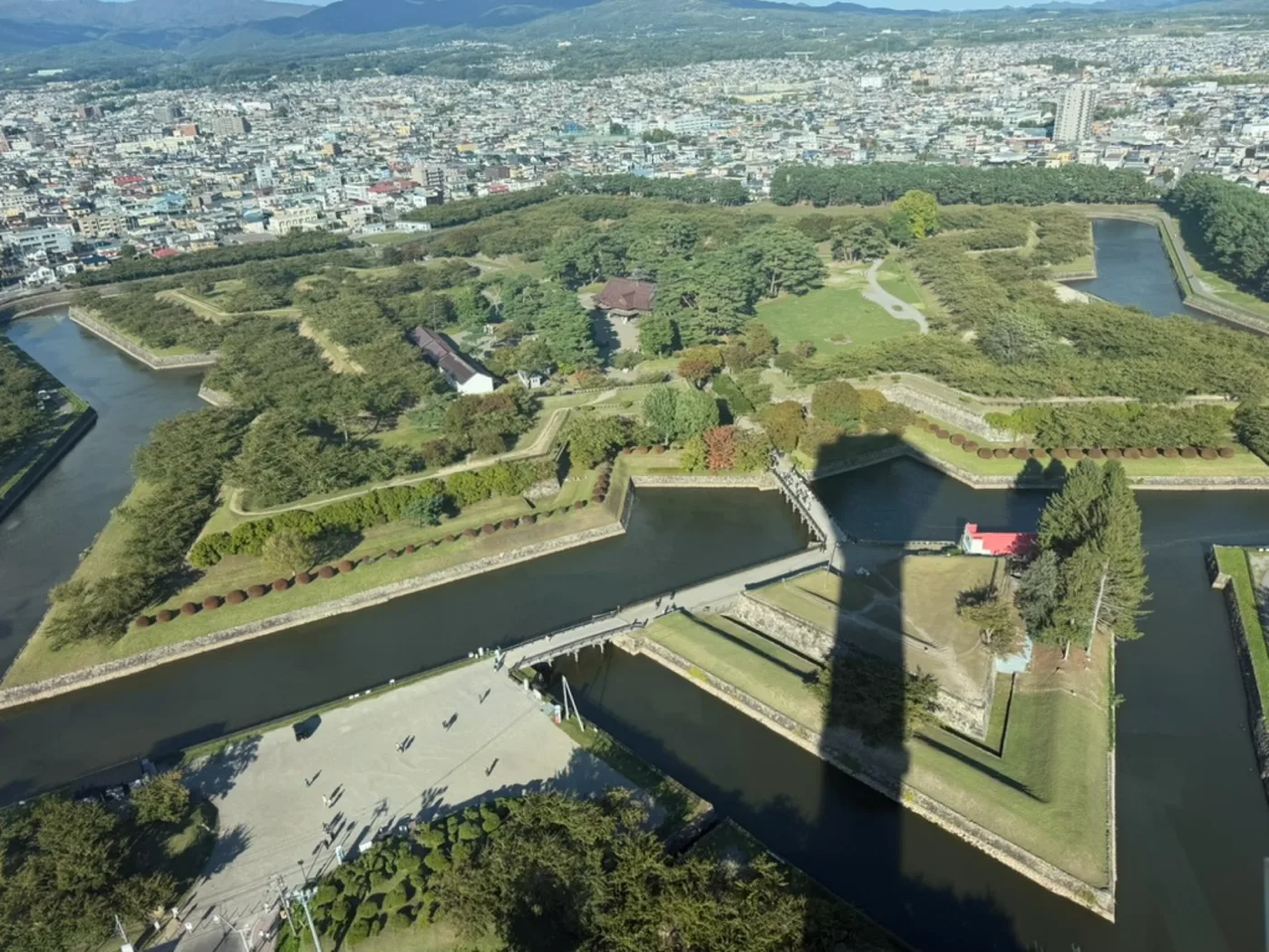 An aerial view of Goryokaku, the star-shaped fortress in Hakodate, surrounded by its moat with the city beyond.